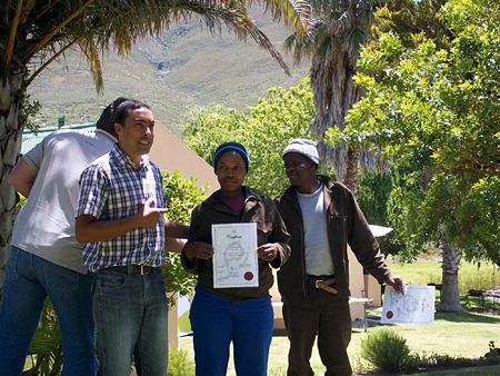 Roger Bailey proudly presenting certificates to Flower Valley Farm workers who have completed the sustainable harvesting training.